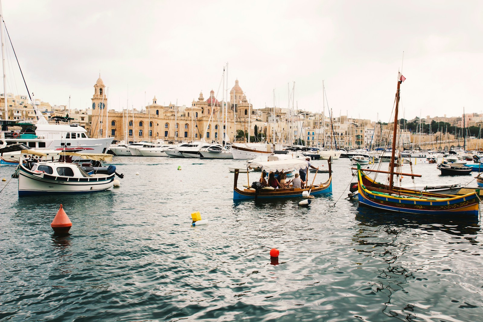 Boats docked in a harbor with city buildings behind