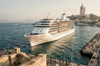 Paquebot de croisière quittant le port de Marseille avec la basilique Notre-Dame de la Garde en arrière-plan